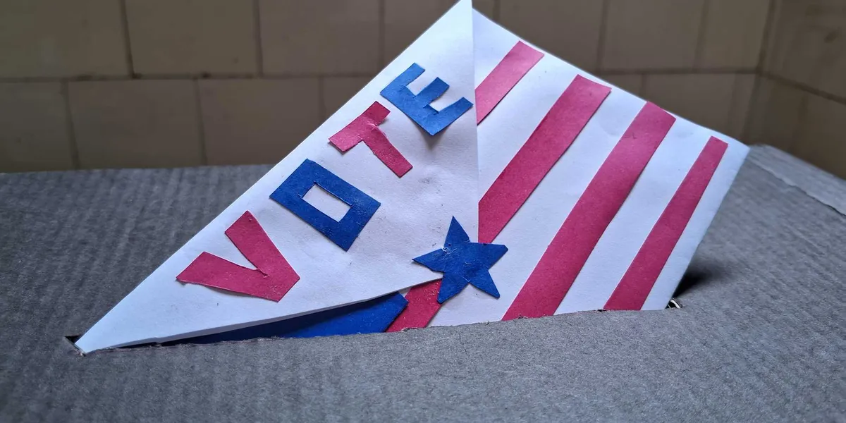 Patriotic paper ballot featuring red and blue stripes with the word vote